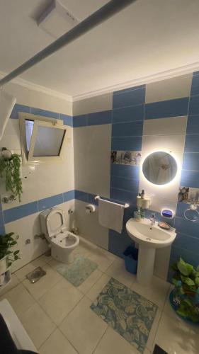 a blue and white bathroom with a toilet and a sink at Gardinia city compound, Nasr city in Cairo