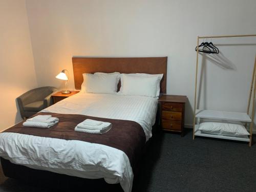 1 dormitorio con 1 cama grande y 2 toallas. en The Reserve Hotel, en Sale