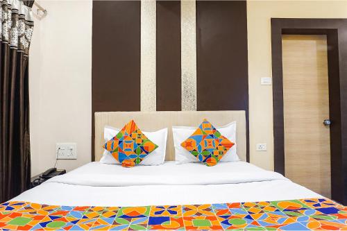 a bed with colorful pillows on top of it at FabHotel Krishna Regency in Pune