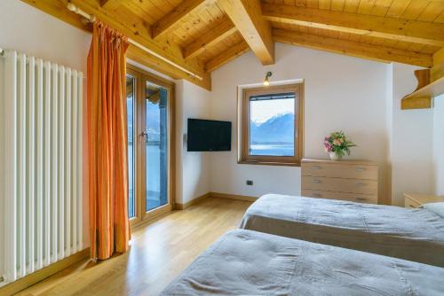 a bedroom with two beds and a window at Villetta Maurizia in Domaso