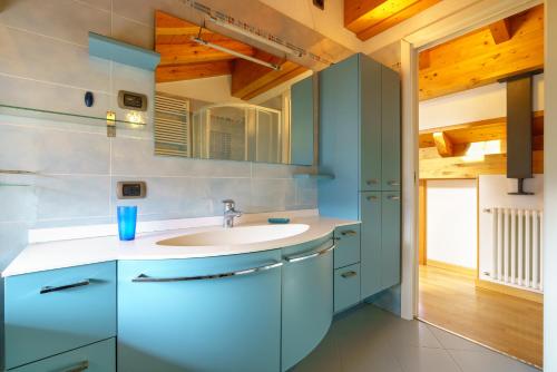 a bathroom with blue cabinets and a sink at Villetta Maurizia in Domaso