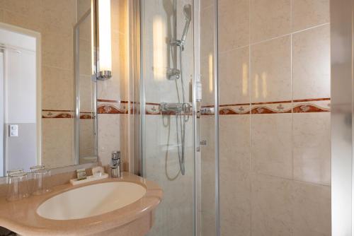 a bathroom with a sink and a shower at Hotel Clément in Paris