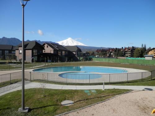 a swimming pool with a snow covered mountain in the background at Casa Costa Pucón in Pucón