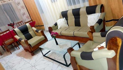 a living room with chairs and a couch and a table at chateau angele w&b in Lomé