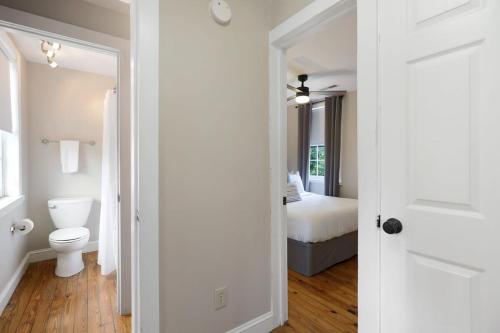 łazienka z toaletą oraz sypialnia z łóżkiem w obiekcie Revitalized Historical Southern Residence w mieście Charleston