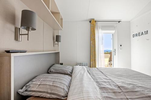 een bed in een kamer met een raam bij Ile d'or parcelle Victor Hugo 1 in Saint-Raphaël