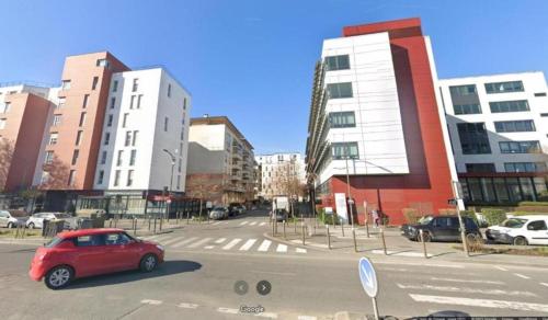 10 min de Paris Appartement touristique ou d'affaires في روسني-سو-بوا: سيارة حمراء متوقفة على شارع في مدينة