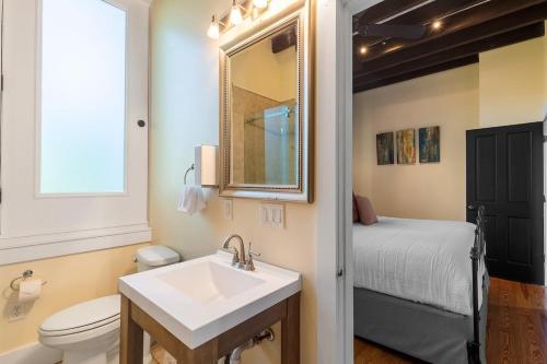 een badkamer met een wastafel, een toilet en een bed bij European Influences in the Heart of Charleston in Charleston