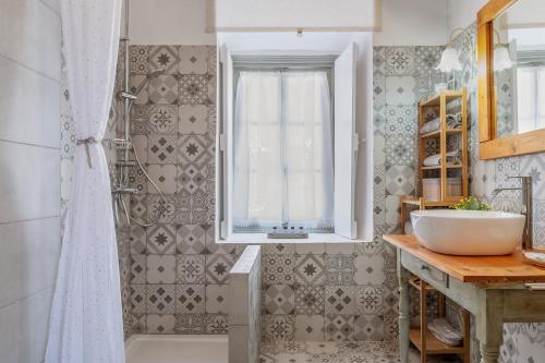 uma casa de banho com um lavatório, uma janela e uma banheira em Martha's House em Spetses