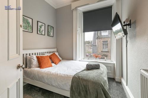 a small bedroom with a bed and a window at Turret Town House in Hawick