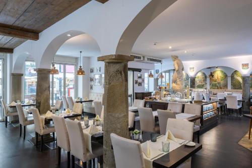 a restaurant with tables and chairs and a statue in the background at Hotel Royal in Vienna