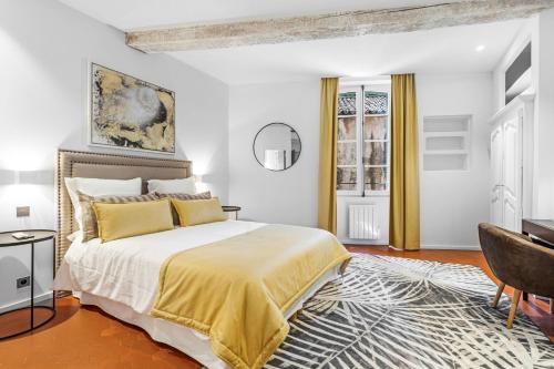 une chambre avec un grand lit et un bureau dans l'établissement Maison Misericorde, à Saint-Tropez