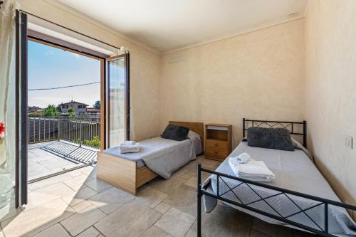 1 dormitorio con 2 camas y balcón en Villa Leonardo, en Calvagese della Riviera