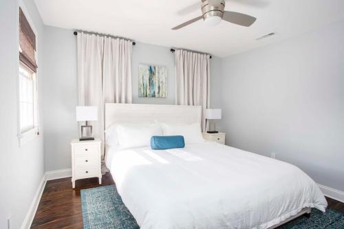 a white bedroom with a white bed and a blue pillow at Freshly Renovated 2 Bedroom Apt 1 Block to King in Charleston