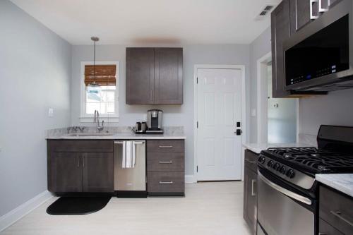 a kitchen with a sink and a stove top oven at Freshly Renovated 2 Bedroom Apt 1 Block to King in Charleston