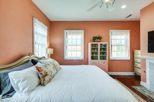 a bedroom with a white bed with orange walls at The Most Charming Old Brick Alley Charleston in Charleston