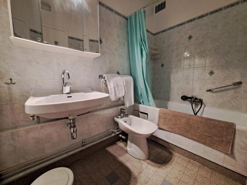 une salle de bain avec un lavabo, des toilettes et une baignoire dans l'établissement Studio Cabine Cosy à Praloup avec Balcon - FR-1-165A-80, à Uvernet
