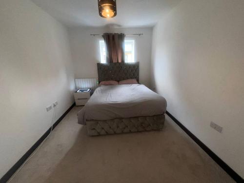 ein Schlafzimmer mit einem Bett in einem weißen Zimmer in der Unterkunft NDO DARTFORD LUXX PRIVATE ENSUITE-ROOM in Dartford