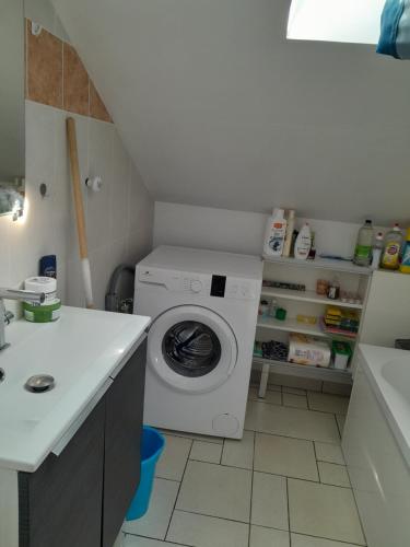 een wasruimte met een wasmachine en een wastafel bij Appartement meublé à 30 minutes de Paris in Mantes-la-Jolie