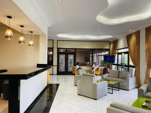 a lobby with couches and a bar in a building at Niagara Hotel in Accra