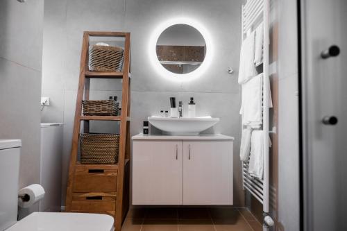 Un baño con un lavabo blanco y un espejo. en Meda Apartments, en Preveza