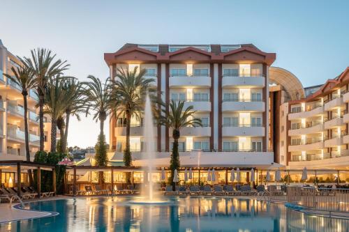 ein Hotel mit einem Pool und Palmen in der Unterkunft ALEGRIA Florida Park in Santa Susanna