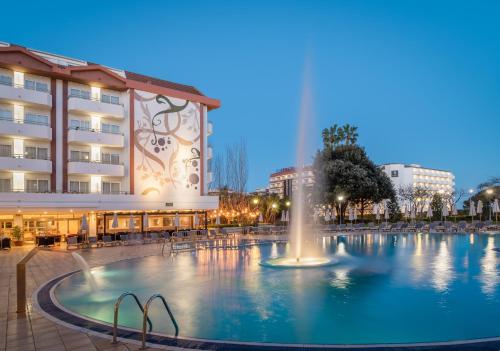 una fuente en una piscina frente a un edificio en ALEGRIA Florida Park, en Santa Susanna