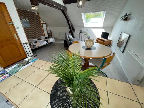 a living room with a table and a plant at Charmant studio à Saulcy-sur-Meurthe, Vosges in Saulcy-sur-Meurthe