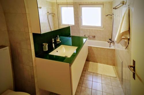 La salle de bains est pourvue d'un lavabo, d'une baignoire et d'un miroir. dans l'établissement Aquae Helveticae, à Baden