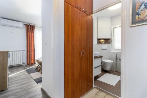 a bathroom with a toilet and a wooden door at Villa Michelle in Pakoštane