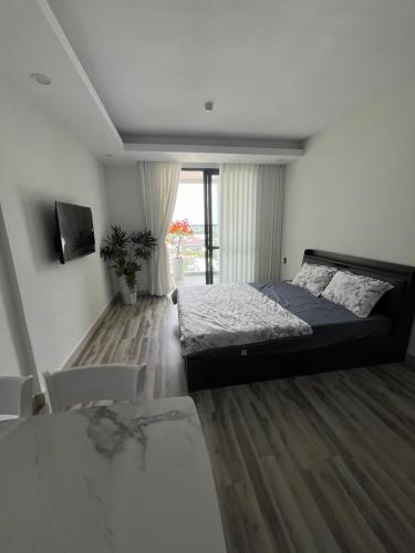 ein Schlafzimmer mit einem Bett und einem TV in der Unterkunft Studio Sofia Center in Ấp Rạch Mẹo