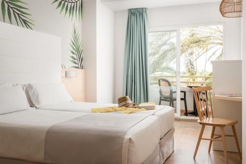 a bedroom with a bed and a desk and a window at ALEGRIA Florida Park in Santa Susanna