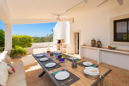 a dining room with a table and a kitchen at Casa do Carmo in Moncarapacho