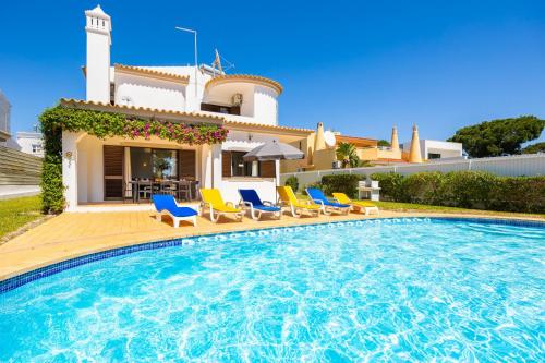 a villa with a swimming pool in front of a house at Villa Cavaco in Vilamoura