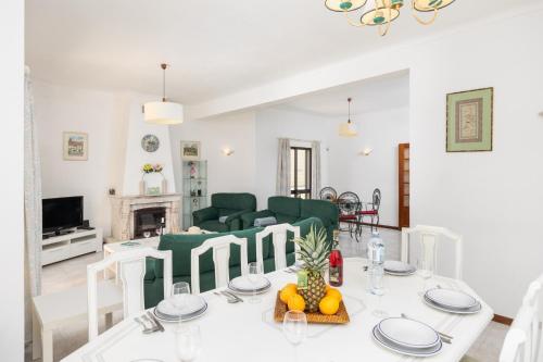 a living room with a table and a couch at Villa Cavaco in Vilamoura