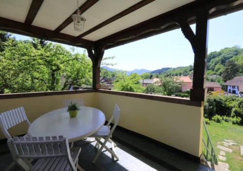 un patio avec une table et des chaises sur un balcon dans l'établissement Gite Les Glycines au coeur de l'Alsace, à Albé