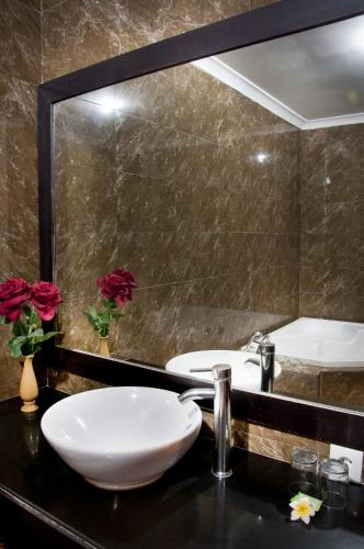a bathroom with two sinks and a large mirror at Sindhu Mertha Suite in Sanur