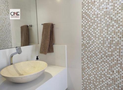 a bathroom with a bowl sink and a mirror at Casa espetacular na praia Brava in Búzios