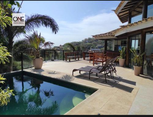 a house with a swimming pool and a patio at Casa espetacular na praia Brava in Búzios