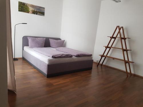 a bed sitting in a room with a wooden floor at Familien-Ferienwohnung Fiwa FeWo-4 in Pirmasens