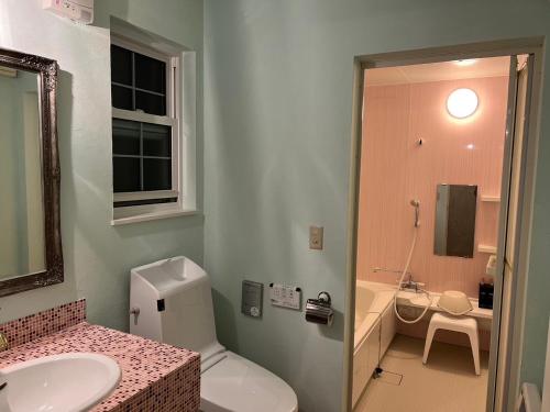Villa美瑛・やさしい窓 في بيي: حمام به مرحاض أبيض ومغسلة