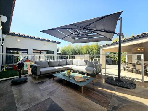 a living room with a couch and an umbrella at Le Paradis secret - piscine - clim - pool-house in Garons