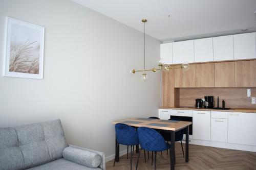 a kitchen with a table and chairs and a couch at Apartos Seaside Garden Apartments I in Świnoujście