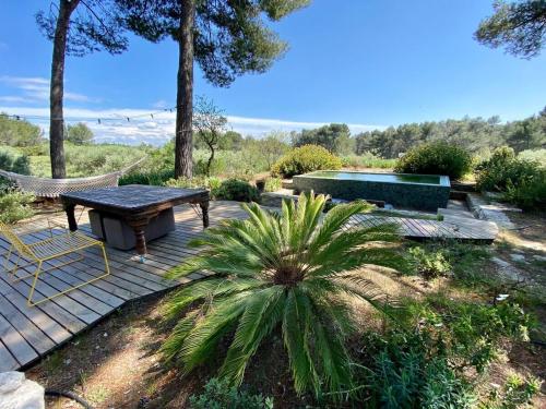d'une terrasse avec un hamac, une table et un banc. dans l'établissement La Planque des Alpilles, à Fontvieille