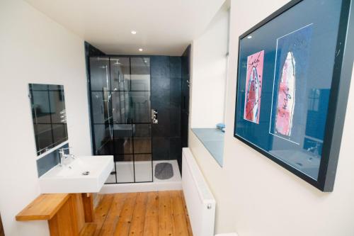 a bathroom with a sink and a shower at Nyth Y Wennol in Brynsiencyn