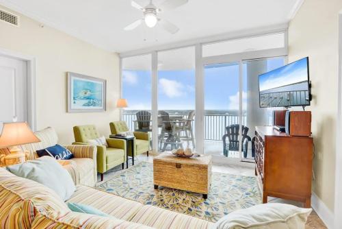 a living room with a couch and a tv at Bel Sole 1102 Spacious water view beach access in Gulf Shores