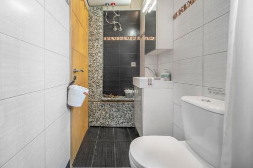 uma casa de banho branca com um WC e um chuveiro em The HostMaster Ethnic Touch Feel Studio em Atenas
