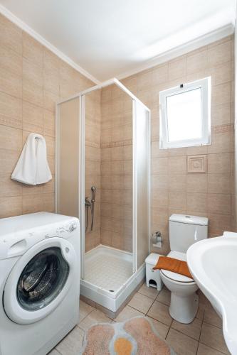 a bathroom with a shower and a washing machine at Niki's House in Gournes
