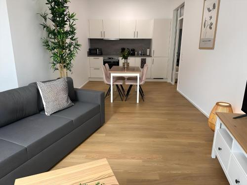 a living room with a couch and a table at Apartment ARTIC II Ausblick & Citylage in Nordhorn