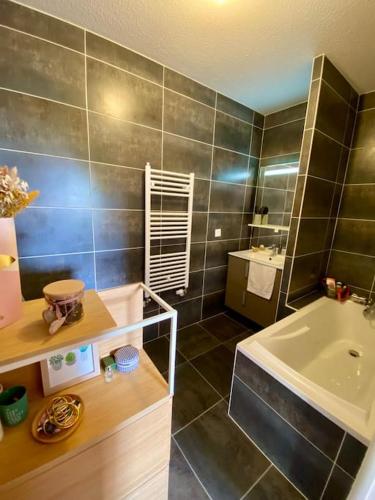 uma casa de banho com um lavatório, uma banheira e um lavatório. em Appartement lumineux et calme em Bordeaux